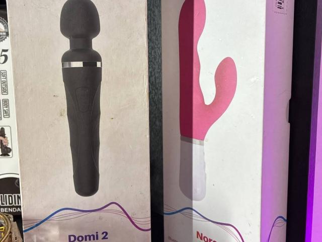 Two sex toys: black wand with silver ring, pink cactus-shaped vibrator with white base. Karimelee's dildo collection, featuring a wand and a cactus vibe.