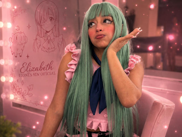 AilenRosse with long green hair, pink frilled top, blue ribbon, pouty lips, hand near face, looking up, pink bokeh lights, cute, soft pink, long nails, feminine, sexy.