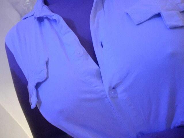 AmmyShtones' blue button-up shirt, slightly wrinkled, with a collar and two buttons, shown from a side angle, resting on a purple surface. Shit looks pretty neat.