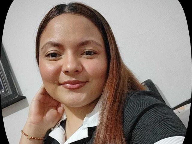 CherryScarlett has light brown skin, long straight brown hair, and a subtle smile. She's wearing a black and white collared shirt, with a bracelet on her right wrist.