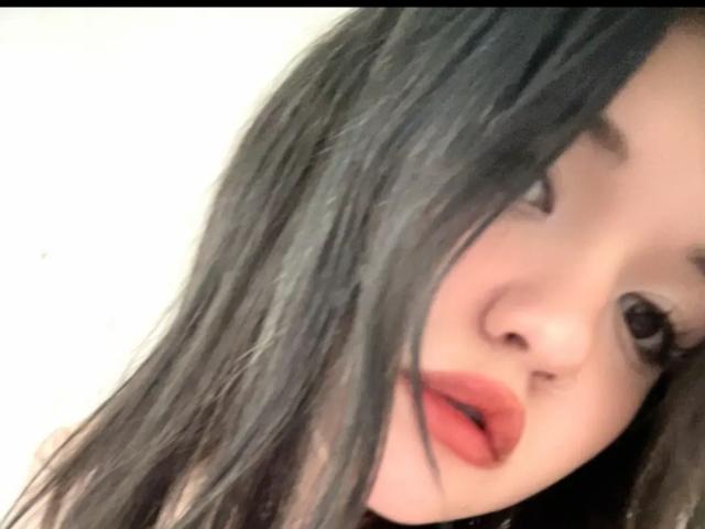 MistyEllstrom's face with long black hair, red lips slightly open, and soft brown eyes. Her nose is centered, and her right eye is partially obscured by her hair.