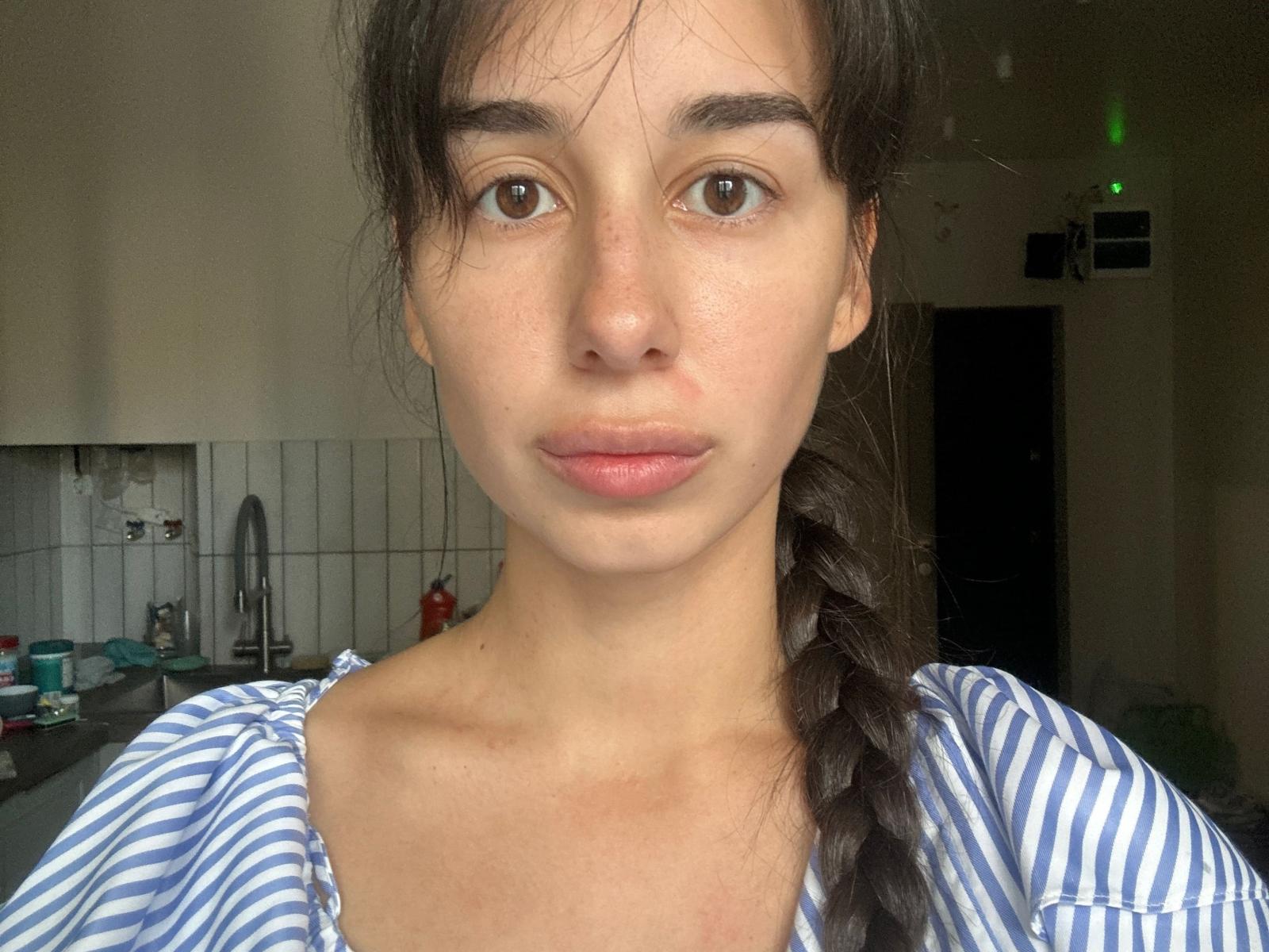 MillyGragert has a pretty face, brown eyes, and a slight freckle pattern. She's wearing a blue and white striped top with a long braid over her right shoulder.