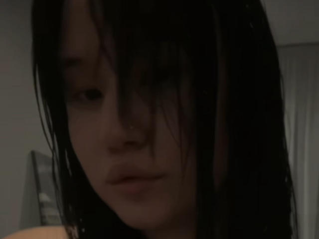 Zita Sutterfield ha i capelli scuri e umidi che le coprono gli occhi e un'espressione neutra. Il suo naso è leggermente all'insù. Si trova in una foto scura e sfocata..