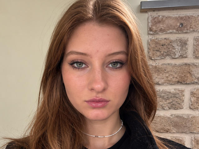 Ardelle Cooksey tiene ojos verdes, labios rosados y cabello castaño. Lleva puesto algo negro y un collar de plata. Su trasero no es visible. Su rostro está centrado en la foto..