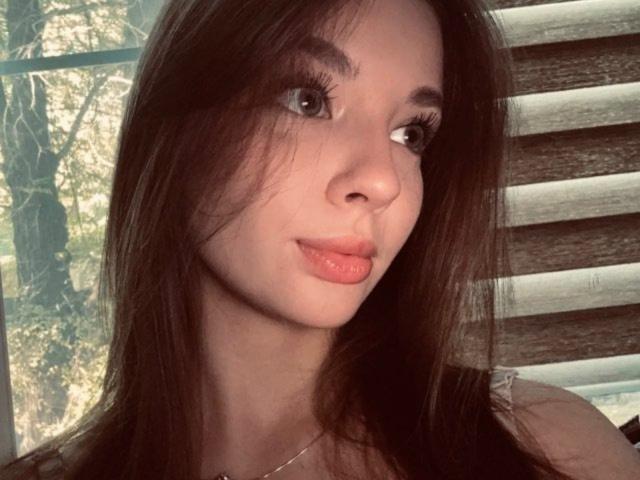 CamilleRamaswamy has pouty pink lips, long brown hair, and thick eyelashes. She's looking to the side with a slight smile. Her tits aren't visible.