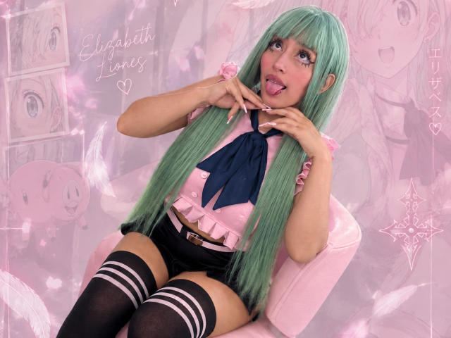 AilenRosse with green hair, tongue out, wearing a pink shirt, blue necktie, black shorts, and thigh-high socks, hands near face, sitting on a pink chair. Digital art.