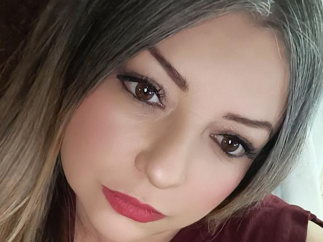 NatalyHami has a cute face with brown eyes, thick eyebrows, pink lipstick, and light brown hair. Her ass is not visible, only her face is shown.