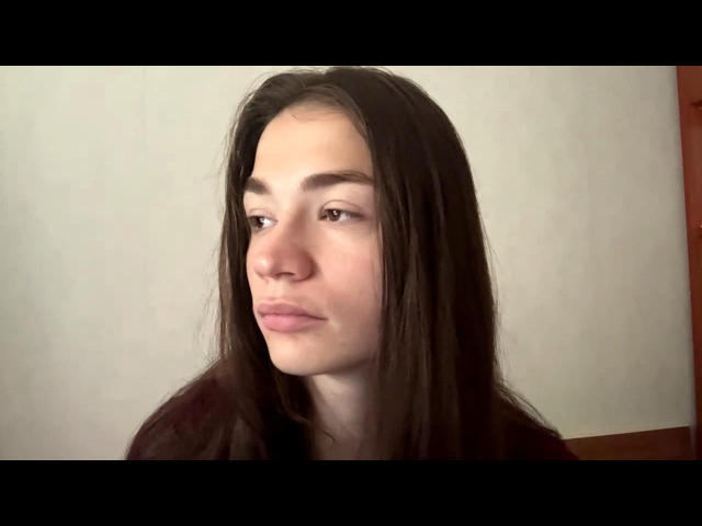 ShelleyVangompel has long brown hair, light skin, and pink lips with a slight pout, looking to the side with a calm expression. Her tits aren't visible.
