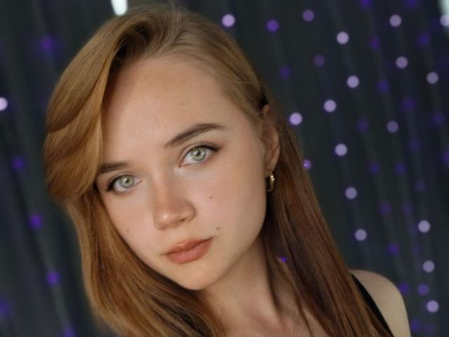 Deidra Weisenhorn a les yeux vert clair, les cheveux châtains raides, un petit nez et un sourire discret avec des lèvres rosées claires. Elle porte des boucles d'oreilles dorées et un haut noir..