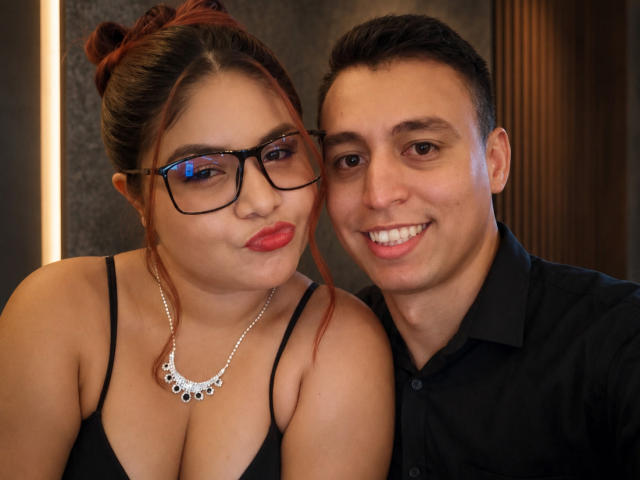 Kappuru with big tits and red lipstick, wearing black glasses and necklace, next to Kappuru with short black hair, smiling in a black shirt. Both have cute faces.