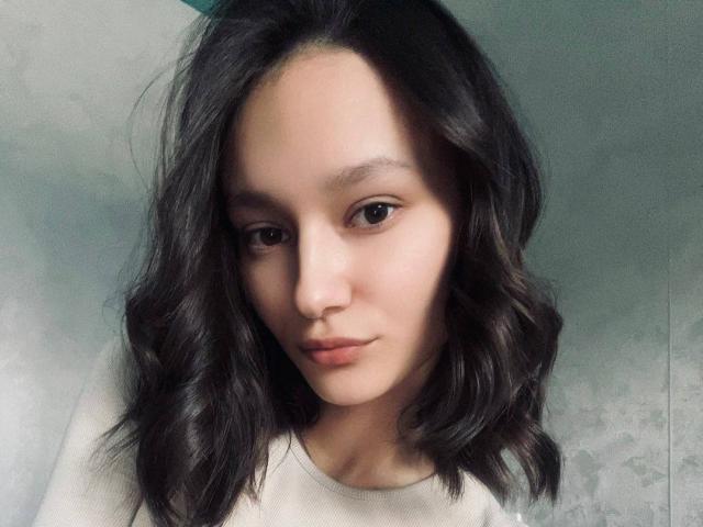 ShanGrines a les cheveux noirs ondulés, une peau claire et une expression sérieuse. Elle porte une chemise blanche, avec un maquillage discret et des sourcils naturels. Elle regarde directement l'appareil photo..