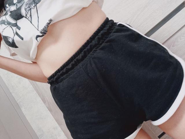 WollyMolly's ass in black shorts, showing a bit of her pale skin and white shirt, with her hand raised above. Black and white shorts, slightly visible white trim.