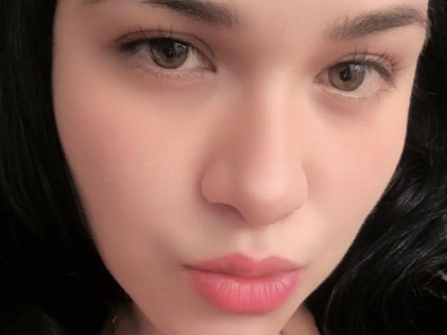 VivianaThompson's face with her nose, brown eyes, black hair, and pink lips. Her slightly parted lips and subtle makeup highlight her pretty, sexy features.