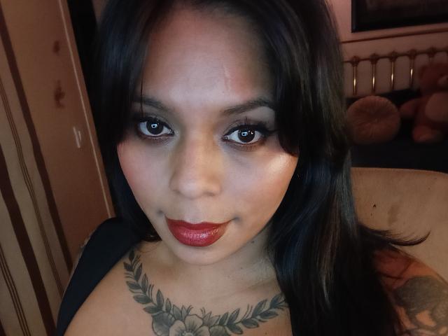 Chili hat dunkles, glattes Haar, braune Augen und roten Lippenstift. Sie hat ein Blatt-Tattoo auf ihrer Brust und eine kleine Narbe auf ihrer Stirn. Ihre Brüste sind klein..
