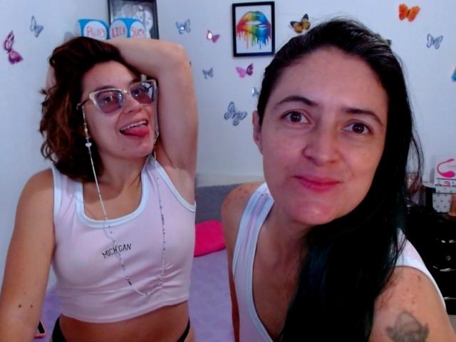 LunaVenus with glasses and tongue out, white sports bra showing her tits, earbuds, and dark wavy hair. LunaVenus with black hair, pink lips, and white tank top.