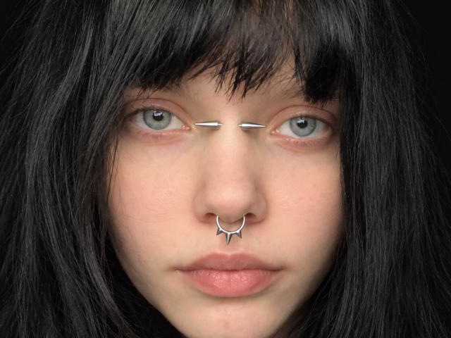 Marianna Warren tem cabelo preto e liso, com franja, um piercing de prata no nariz com um pequeno design pontiagudo, e barras de prata paralelas que se estendem até os olhos. Seus olhos azuis estão centralizados..
