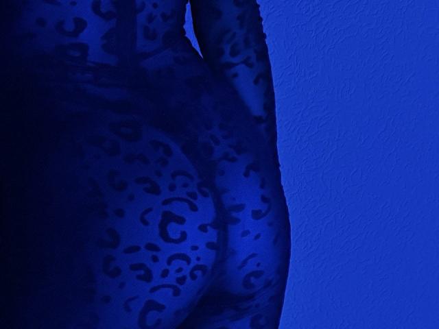 Les fesses de BalletSwan, dans une combinaison moulante bleue à imprimé léopard, mettant en valeur ses fesses rondes et ornées de motifs. L'image est bleu foncé avec des taches de léopard noires..