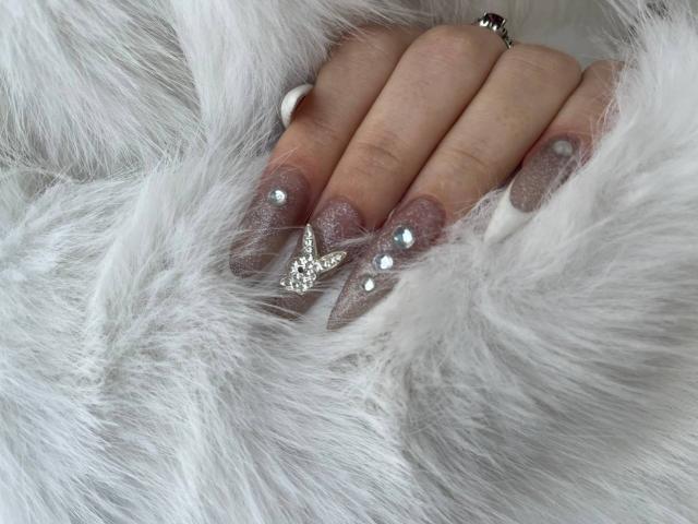 FallenAngelia's hands with sparkly gray nails, glitter tips, and a star-shaped silver ring, resting on fluffy white fur. Her ringed finger is slightly curled.