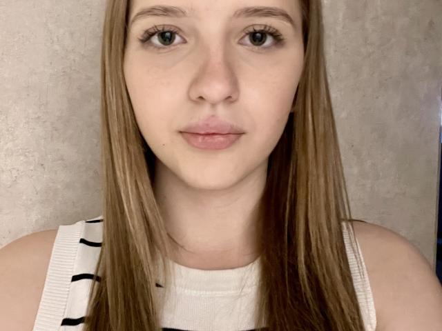 Treasa Dilox heeft een lichte huid, groene ogen en steil bruin haar, en draagt een wit topje zonder mouwen met zwarte strepen. Haar volle lippen zijn lichtjes samengeknepen..