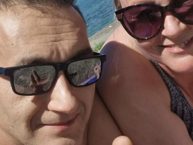 AngeAndDamon with dark sunglasses reflecting a hand, next to Damon with a smiling, middle-aged woman in dark sunglasses and a grey top, showing her tits slightly.