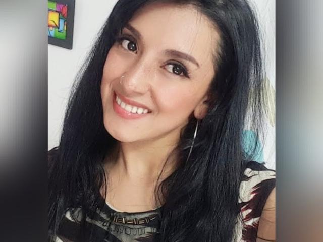 HotCarolinexx heeft lang zwart haar, een schattige neusring en glimlacht met witte tanden. Ze draagt een top met een patroon en heeft oorringen. Ze ziet er erg aantrekkelijk uit..