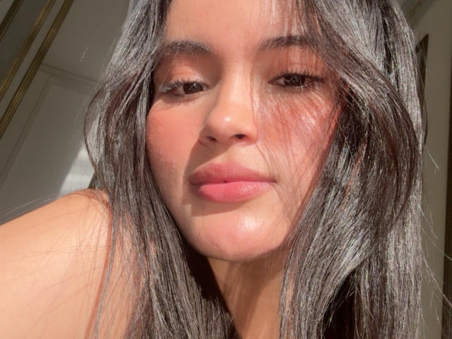 MiiaPalmer's face, showing off her pink lips and long, wavy grayish-brown hair, with sunlight highlighting her slightly flushed skin and relaxed expression.