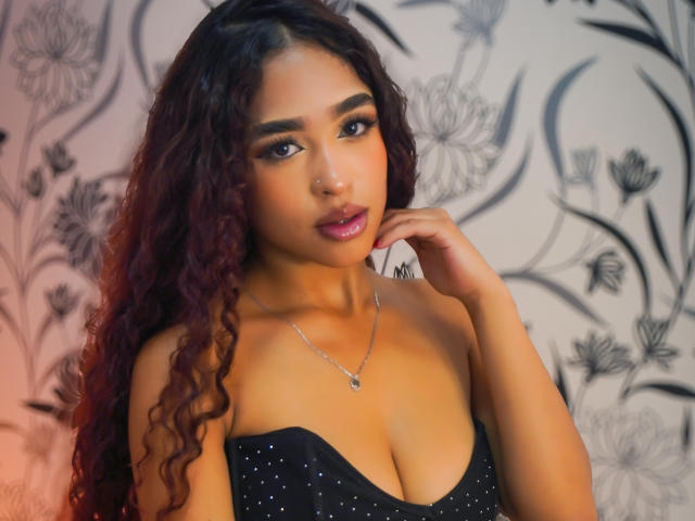 Madison Dawson heeft krullend donkerrood haar, bruine ogen en draagt een zwarte jurk zonder bandjes met kleine glitters, die haar borsten laat zien, met een zilveren ketting en roze lippenstift..