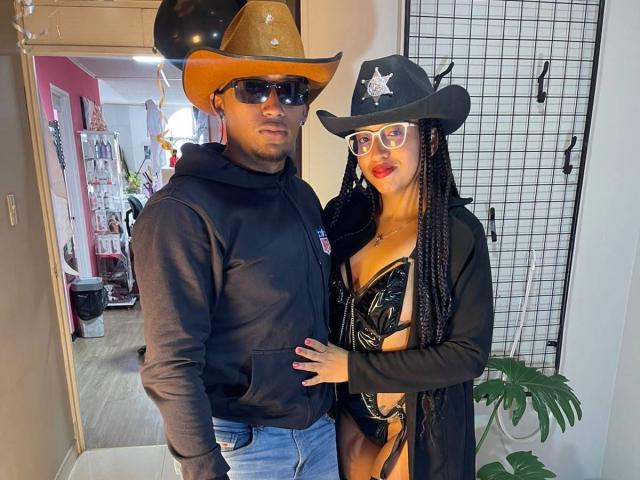 LilithAndAsmodeo con un cappello da cowboy nero, occhiali da sole scuri e una felpa, in piedi accanto a LilithAndAsmodeo con un cappello nero, una stella, occhiali e un bikini di pelle nera, che mostra un seno abbondante..