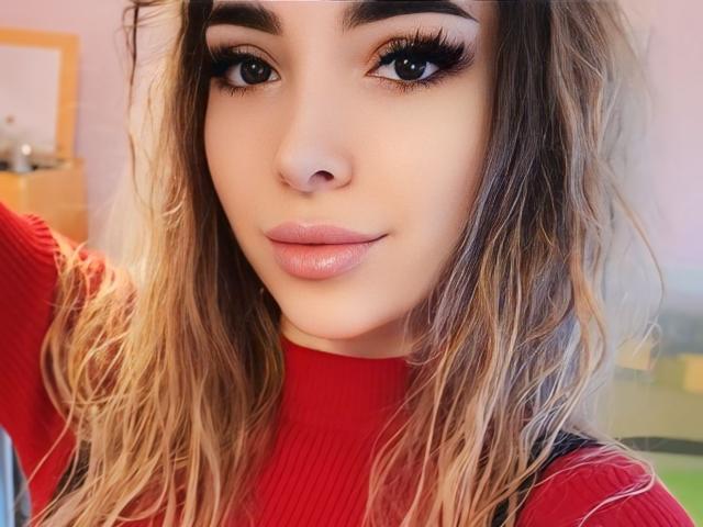 YukiCherry ha i capelli biondi ondulati, sopracciglia folte, lunghe ciglia e labbra rosa lucide, e indossa un maglione rosso a coste. Il suo seno non è visibile..