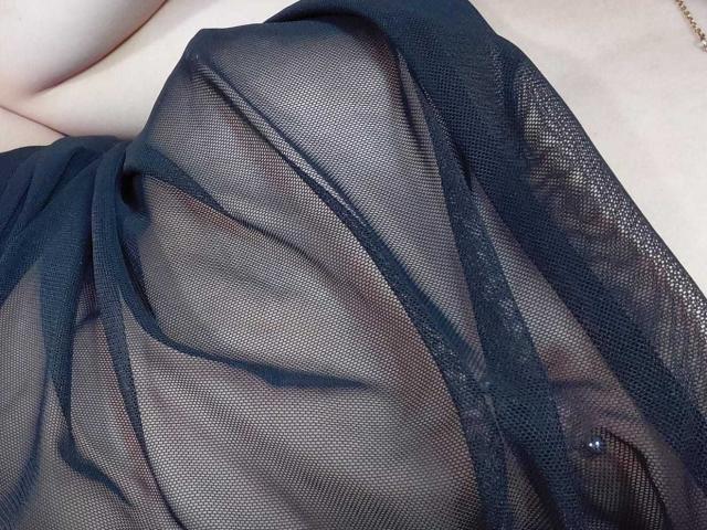 CherryBuchel's black mesh dress, sheer and revealing, shows her pale skin and the curve of her breast, with a hint of her nipple through the fabric.