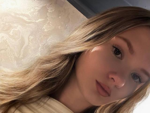Solange Gulsvig a les cheveux blonds, une peau claire et des lèvres pulpeuses avec un léger sourire, et elle regarde l'appareil photo avec ses yeux marron. Son visage est légèrement incliné vers la droite..
