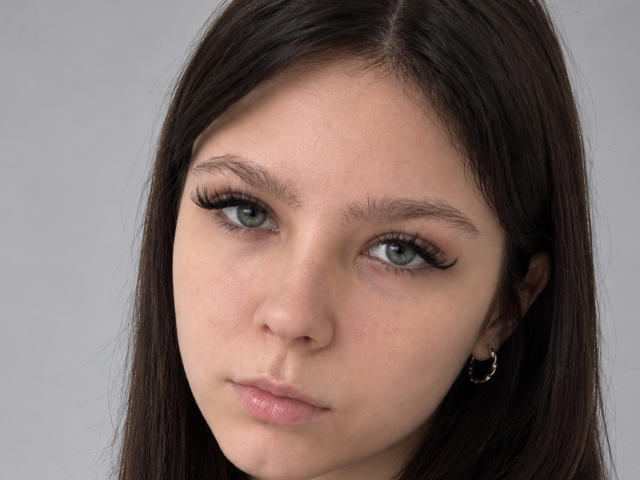 MertieSusoev a les yeux verts, de longs cheveux bruns foncés, des cils noirs épais, des lèvres roses claires et un petit anneau à son oreille droite. Son visage est légèrement boudeur..