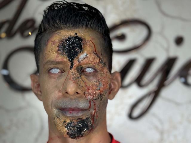 JoseRumBerotop has a creepy, realistic zombie face with cracked, bloody skin, black and red patches, and glowing blue eyes, standing against a blurred white background.