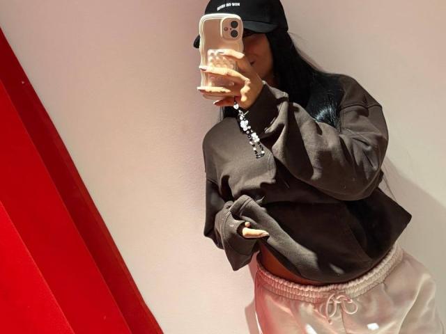 AntonellaMonroe takes a mirror selfie, wearing a black hoodie, white pants, and a black cap, with long black hair, holding a phone with a cream case, showing her ass.