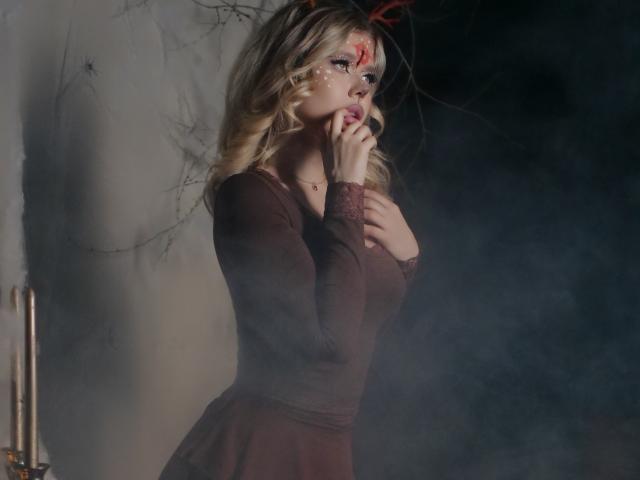 FollowLove with blonde hair, blood on her face, wearing a brown dress, hands near mouth, looking up, smoke in background, red ribbon in hair, dark and moody setting.