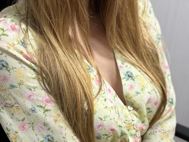 Viloriia's tits are covered by a floral, button-up shirt with pink and blue flowers. Her blonde hair is straight and falls over her chest.