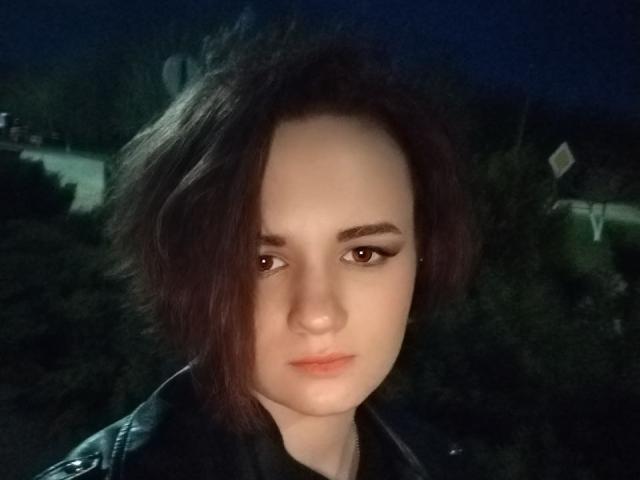 TreenaVisosky with short dark brown hair, light skin, and brown eyes, wearing a black leather jacket, looking slightly to the side with a neutral expression.