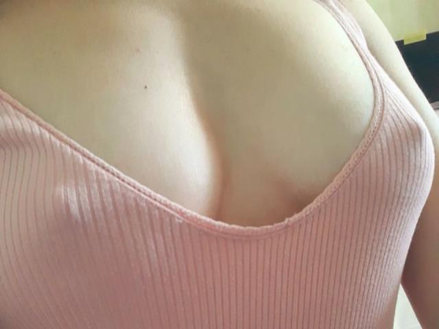 Orshiti's pale skin, showing her large, round, pink ribbed tank top-covered tits with visible cleavage and soft, smooth skin.