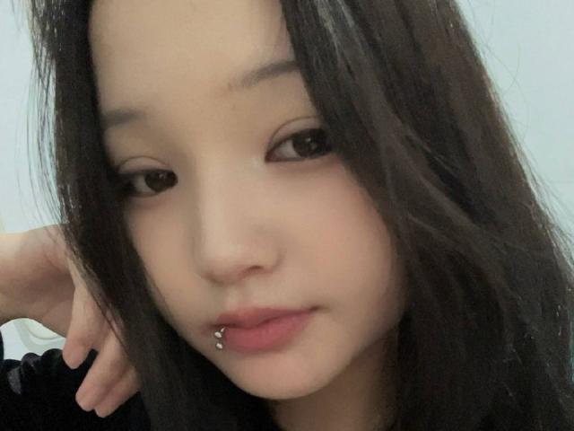 RayeAbend has long dark hair, a nose piercing, and a lip piercing with a small ball on her bottom lip, looking at the camera with a slight smile.