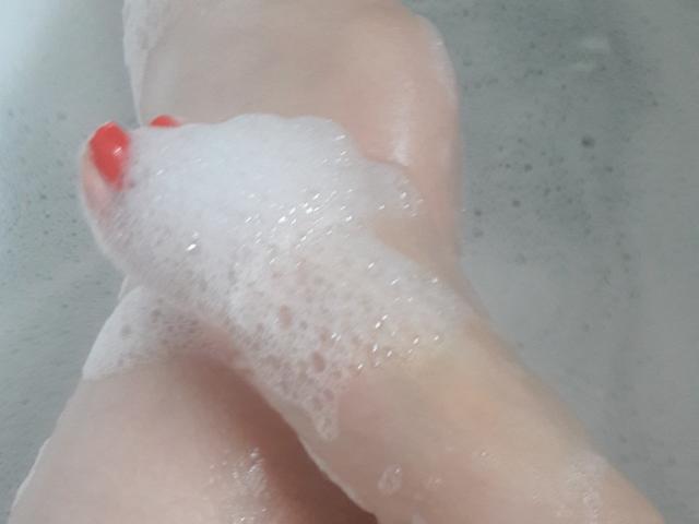 FrenchLea's foot with red-painted toes is covered in white soap suds, showing a wet and slightly curved position in a bath.