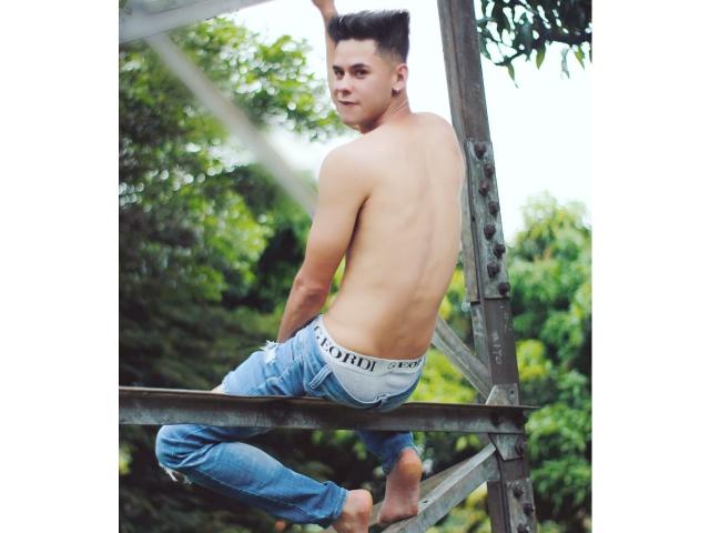 DerrickBigX is shirtless, sitting on a metal ladder, with his back to the camera, showing his toned ass in white Calvin Klein underwear and blue jeans.