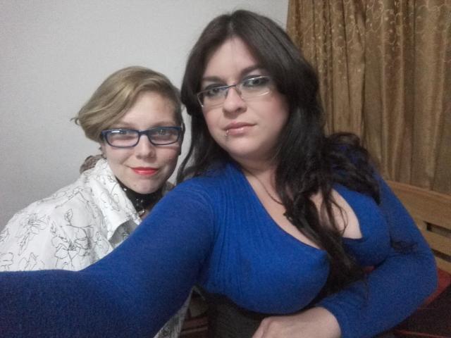 Zwei lateinamerikanische Frauen, die als "Hard Girls" bezeichnet werden, auf einem Foto; eine mit blonden Haaren, Brille und einem weißen, gemusterten Hemd, die andere mit schwarzen Haaren, Brille und einem blauen Oberteil, das ihre Brüste zeigt..