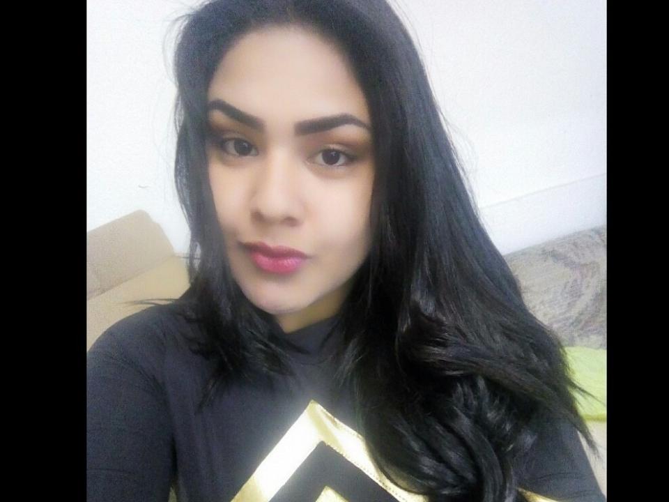 Kyldan tem cabelo preto, olhos castanhos e está vestindo uma camisa preta com um triângulo dourado. Seus lábios rosados estão ligeiramente entreabertos. Ela olha diretamente para a câmera..