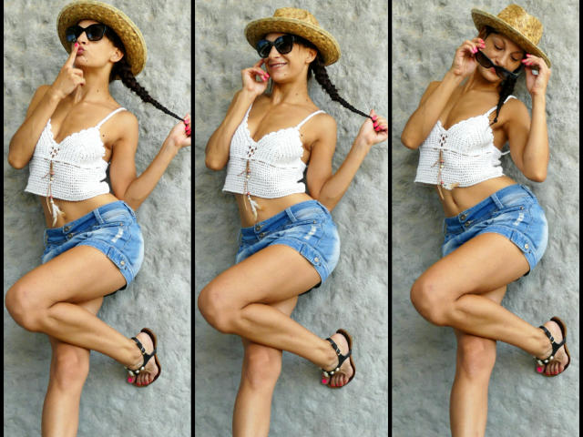 CassandraMichelli is lying down, wearing a straw hat, black sunglasses, white crochet top, blue denim shorts, and sandals. She's touching her braid and smiling with her eyes closed.
