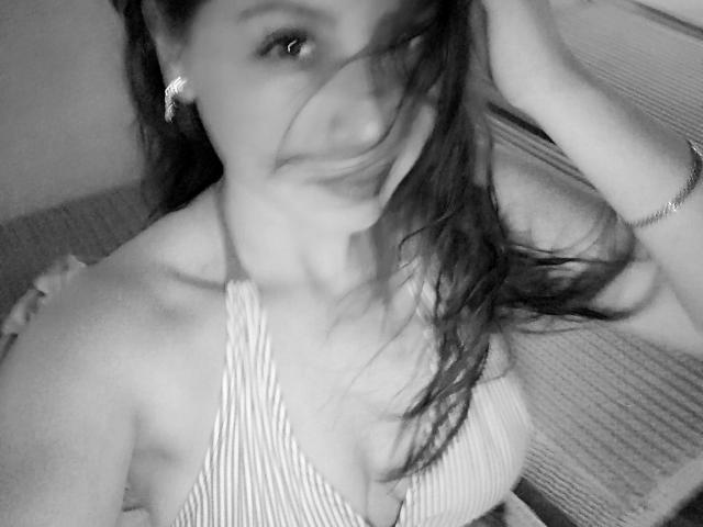Black-and-white selfie of KaterinaSalvatore with wet, dark hair covering her face, wearing a striped halter top, showing her tits, and a bracelet on her right wrist.