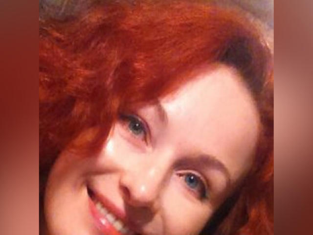 Marlene Davies tem cabelo ruivo e encaracolado, olhos azuis e um rosto sorridente com pele clara. Seu nariz é ligeiramente arrebitado, e ela está olhando para a direita..