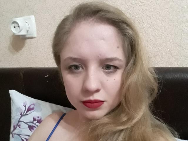 Lidaohlove heeft bleke huid, blond golvend haar, rode lippenstift, blauwe ogen en een kleine moedervlek op haar rechterwang, en draagt een blauwe bandje, tegen een donkerbruine hoofdsteun..