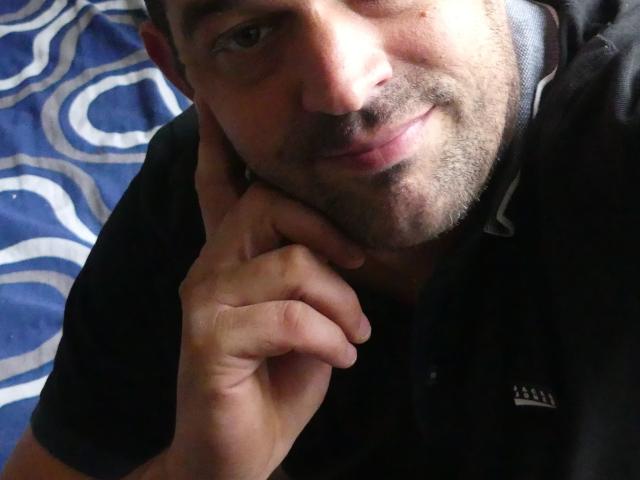 JuliCandy met volmaakte, roze lippen, blond golvend haar, bruine ogen en een bloemenjurk, die haar borsten en schattige gezicht laat zien in een selfie..