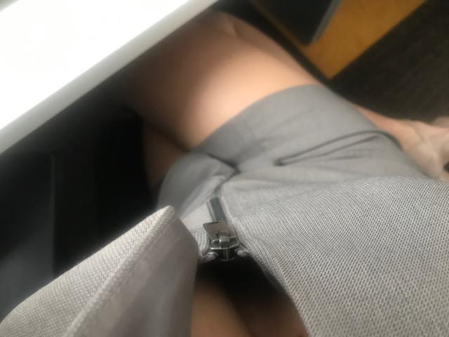 KatieFrenchie's gray shorts are zipped down, revealing her bare pussy. Her skin is tan, and she's lying down with her thighs spread. The image is a selfie.