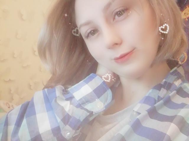 NaozuQAce with light brown hair, wearing a blue and white checkered shirt, has small heart-shaped sparkles near her eyes and a slight smile, showing a cute face.